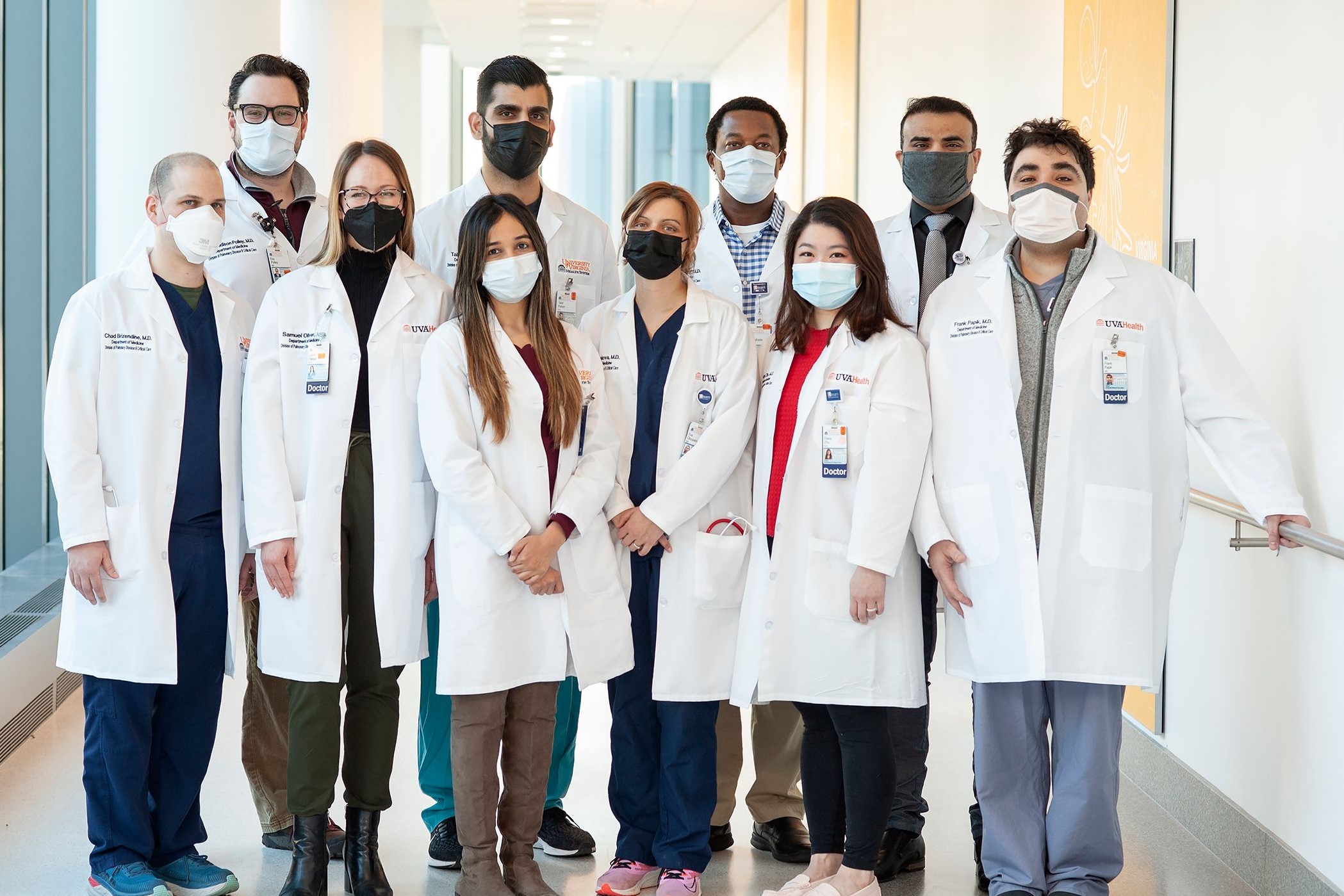 Three healthcare professionals in scrubs and gowns